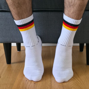 Vista frontal de unos calcetines deportivos blancos de caña acanalada con franjas tricolor retro.