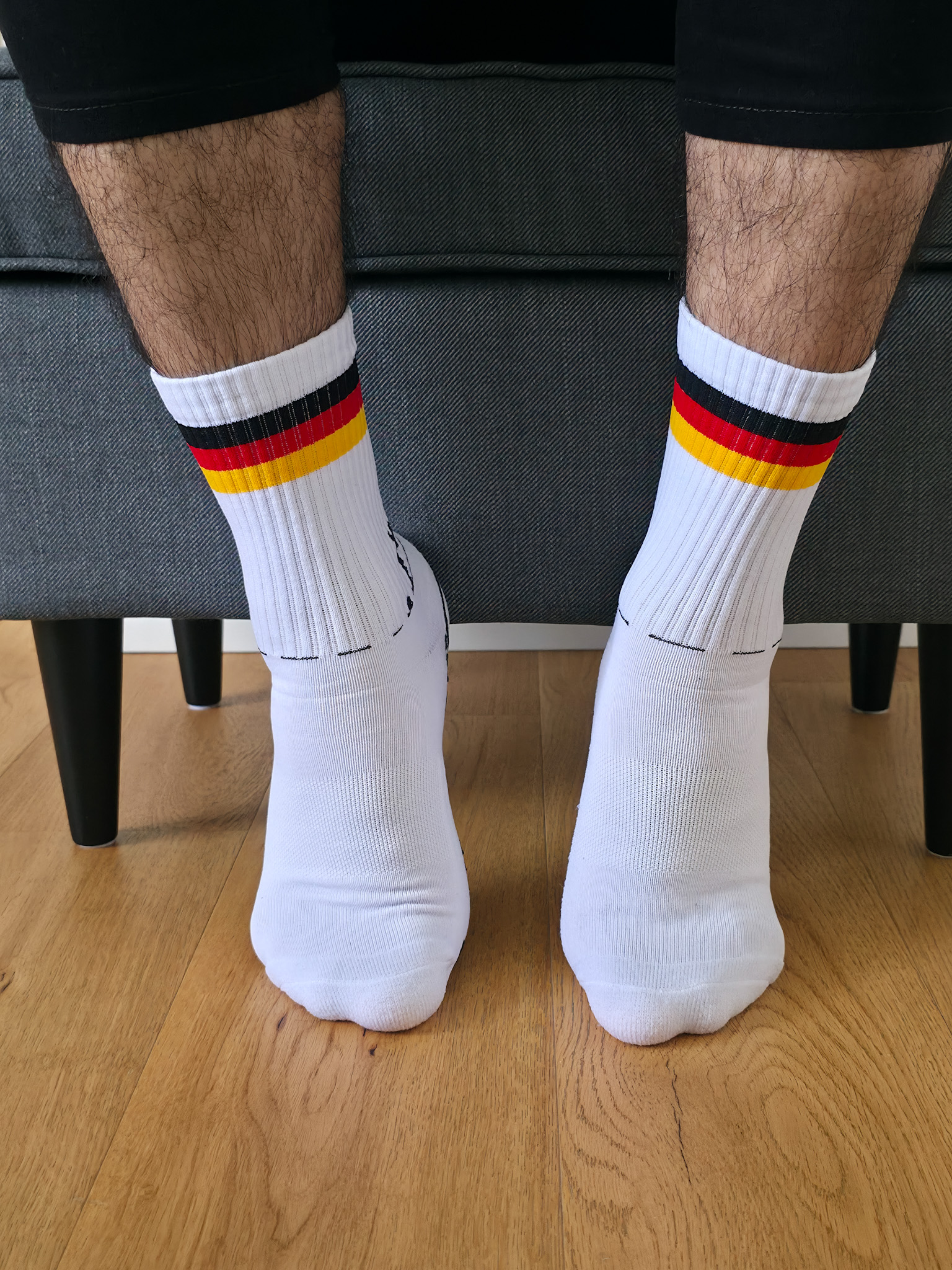Vista frontal de unos calcetines deportivos blancos de caña acanalada con franjas tricolor retro.